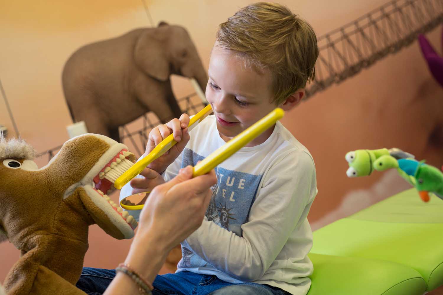 Kind putzt einem Stofftier die Zähne